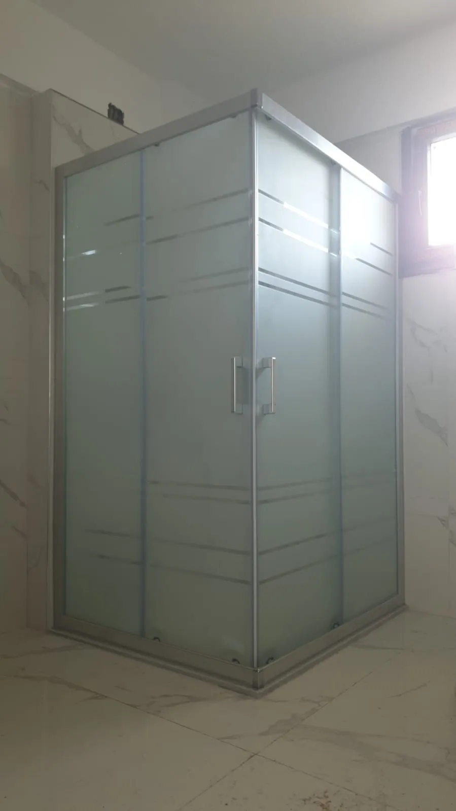Krom profilli köşe duşakabin, ince çizgi desenli buzlu cam, aydınlık banyo