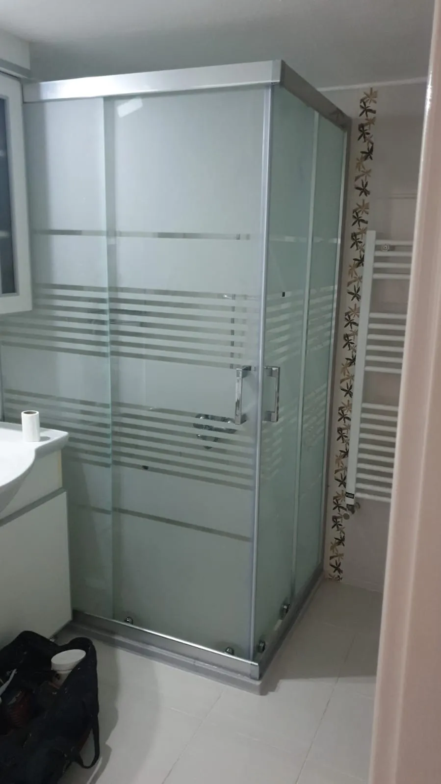 Köşe duşakabin, krom profil ve yatay çizgi kumlamalı cam, dar banyoya ölçüye özel montaj
