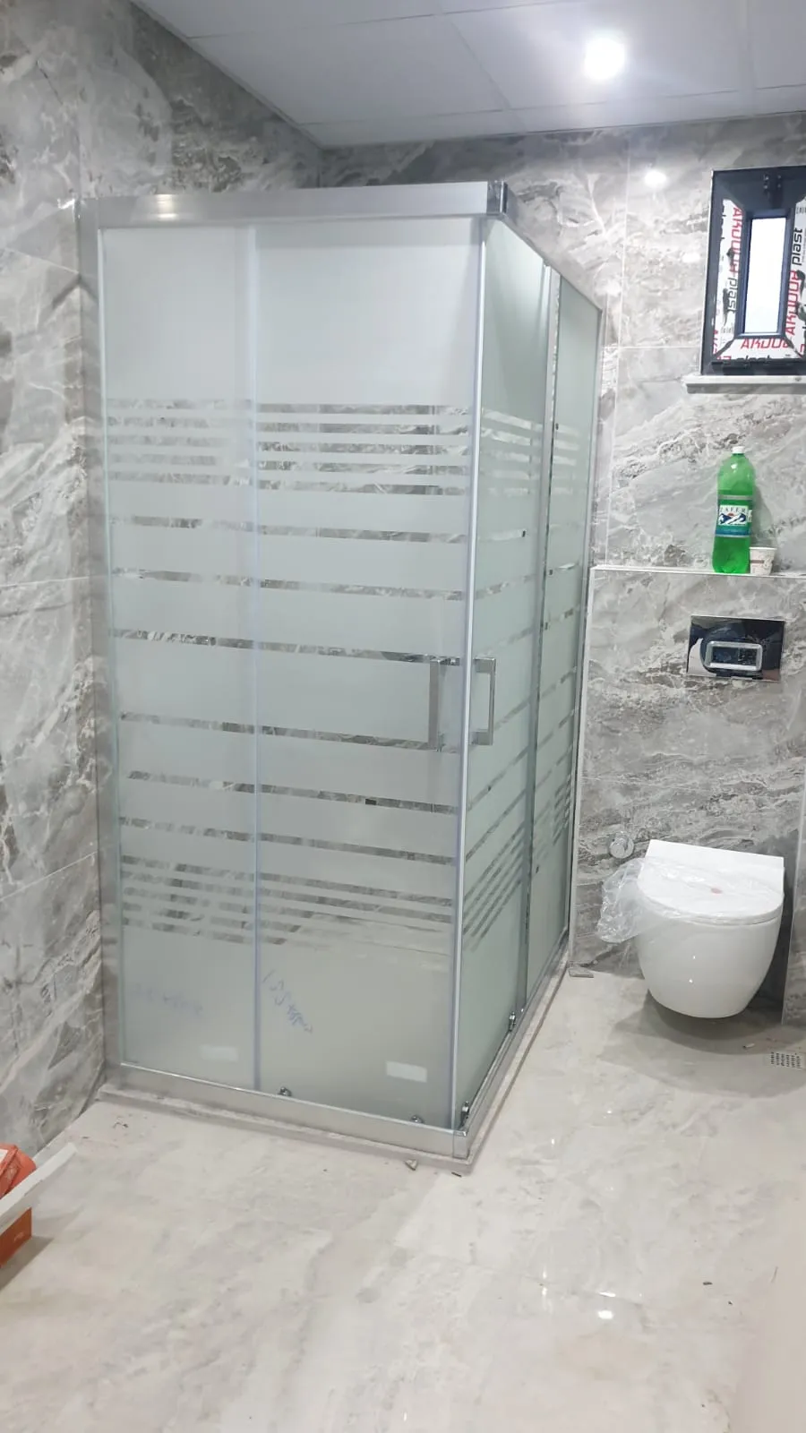 Köşe duşakabin, krom profil, yoğun yatay çizgili kumlama deseni, gri mermer banyo