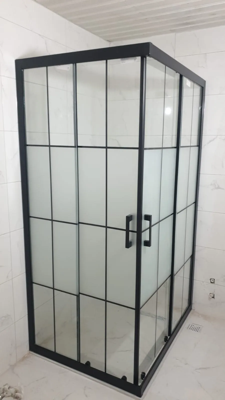 Siyah profilli köşe duşakabin, kareli kumlamalı cam, beyaz banyoda tamamlanmış montaj