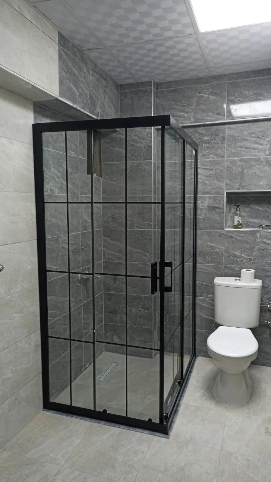 Siyah profilli köşe duşakabin, kareli bölmeli şeffaf cam, antrasit banyo
