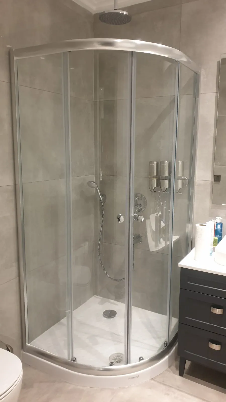 Oval çeyrek daire duşakabin, krom profil ve şeffaf kavisli cam, gri banyo
